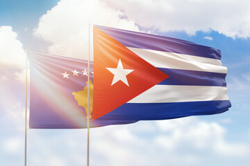 Sunny blue sky and flags of cuba and kosovo