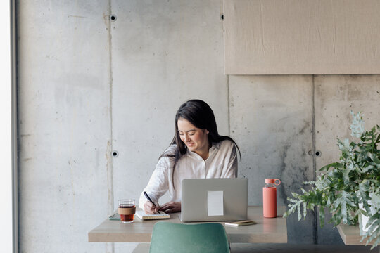 Young Girl Working With Computer in a Cafe