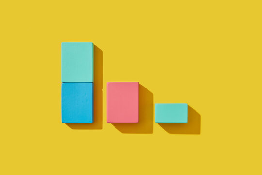 Square shaped wooden blocks lying on yellow background