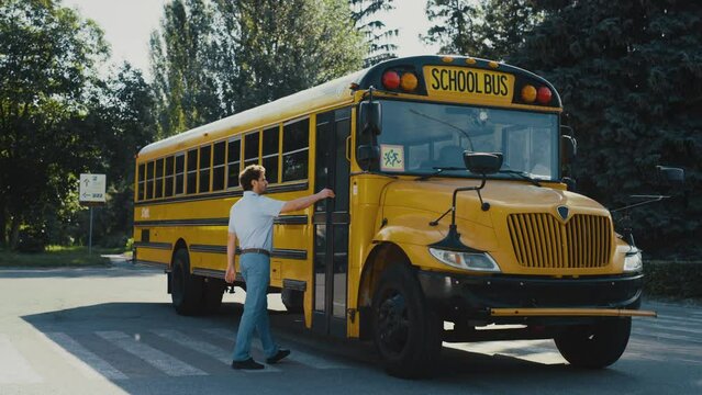 Man driver coming up schoolbus press button alone. Operator enter yellow bus.