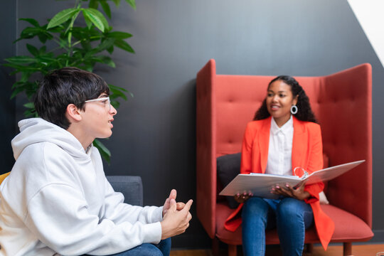 Thoughtful Teenager and principal during office meeting