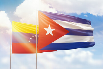 Sunny blue sky and flags of cuba and venezuela
