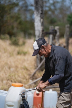 Elderly man repairing a sprayer for fumigation 