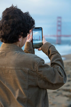 Boy snapping photo of Golden Gate