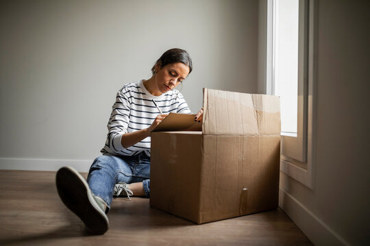 Young woman with a moving box at home