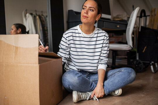 Young woman with a moving box at home