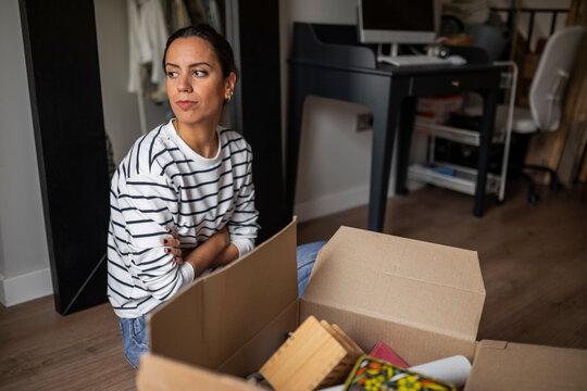 Young woman with a moving box at home