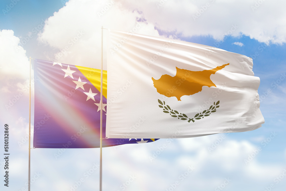 Wall mural sunny blue sky and flags of cyprus and bosnia