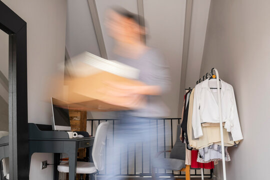 Young woman moving with moving box at home