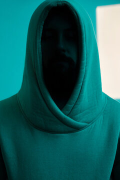 Close portrait of a hooded man with shadowed face