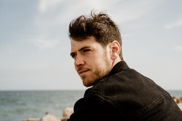 Fototapeta premium Portrait of handsome man outdoors by the beach 