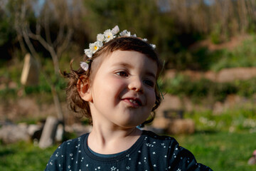 Little girl spring portrait with flowers crown on head