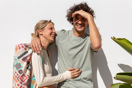 Loving diverse couple hugging and smiling on street