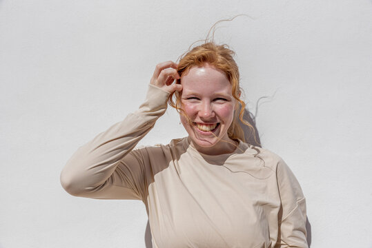 Joyful lady with ginger hair smiling in sunlight