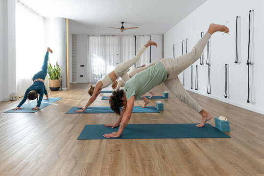 People doing Single leg Downward Facing Dog pose during yoga lesson