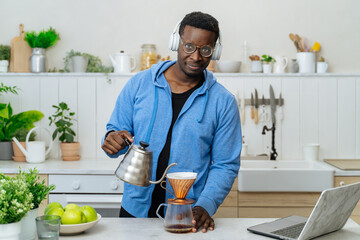 Young black man brewing filter coffee in a kitchen