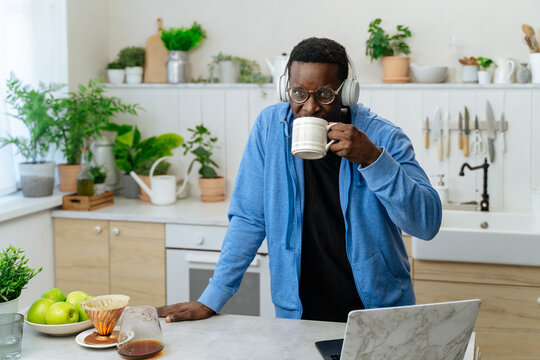 Young black man enjoying mug of coffee in a kitchen