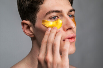Man using under eye patch, male skin care