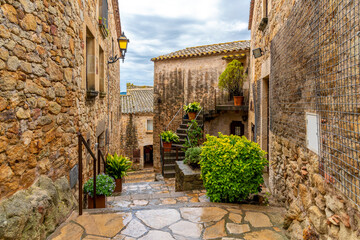 The wet streets of the medieval village of Pals, Spain after a summer rainstorm along the Costa...