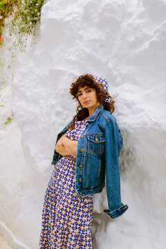 Woman with a mighty looking leaning on a white wall