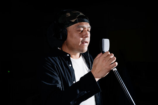 Male singer recording song in music studio