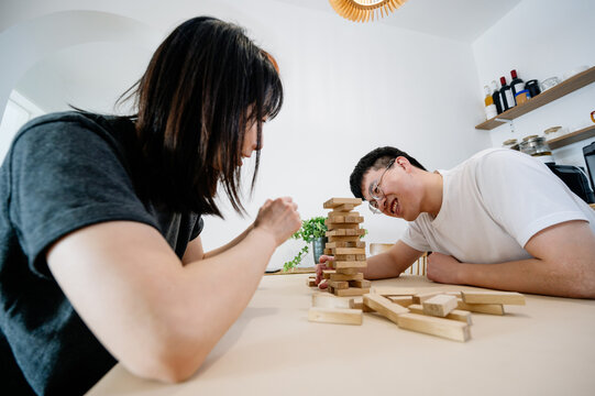 Couples playing blocks balancing at home
