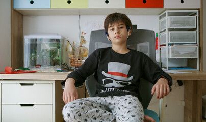 Cute boy sitting in his bedroom