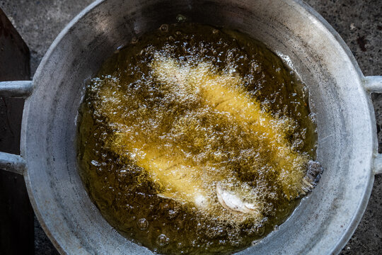 Fresh fish being fried in a pan outdoors