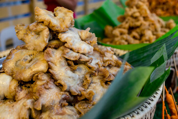 Chicharon Bulaklak and other deep fried food in banana leaf lined rattan baskets for sale at a food...