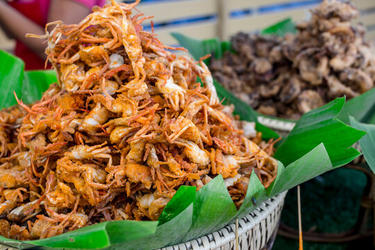 Crispy Crablets and other deep fried food in banana leaf lined rattan baskets for sale at a food stall. Delicious and popular Philippine street food.