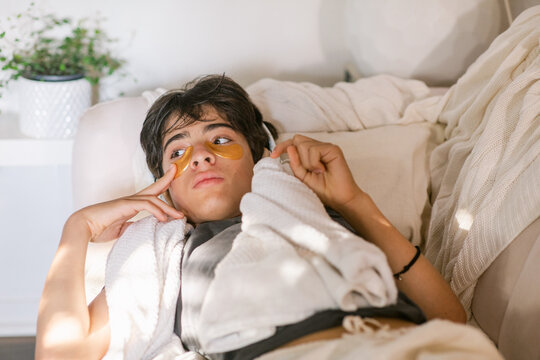 Boy with eye mask resting on sofa