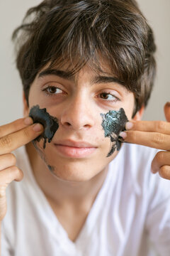 Teen boy applying mask