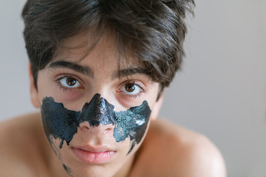 Teen boy with facial mask portrait
