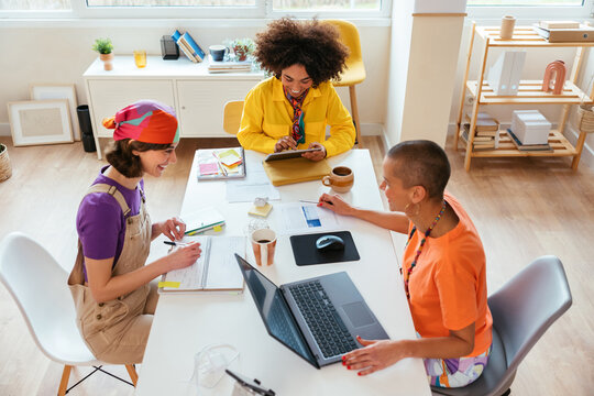 Diverse women working on creative project at table