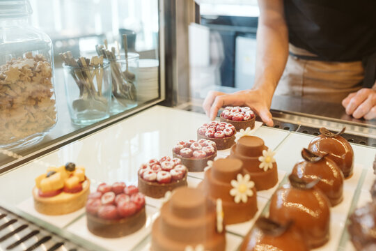 Close-up Of Worker Fixing Desserts In A Bakery