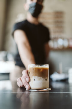 Faceless barista handing over a coffe