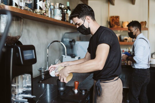 Barista pouring caramel over a coffee