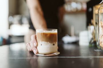 Faceless barista handing over a coffe