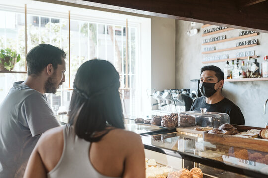 Couple Ordering Baked Goods In A Cafe