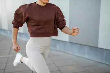 Caucasian female athlete running through the city