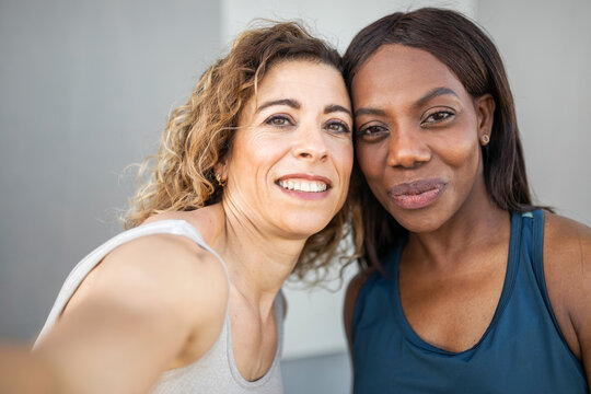 UGC of two Caucasian and Black female friends taking a photo outside i