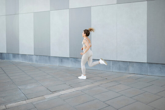 Caucasian female athlete running through the city