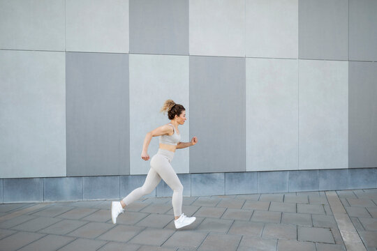 Caucasian female athlete running through the city