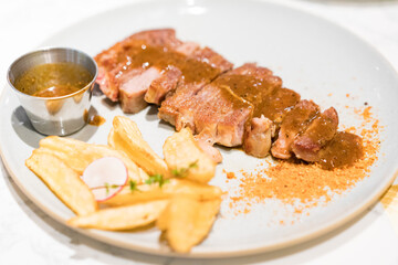 A steak and French fries on the plate