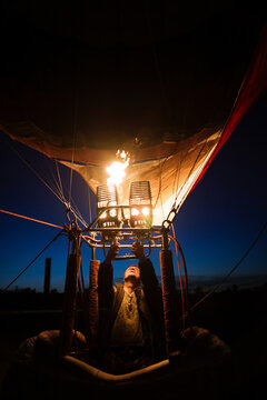 Portrait of hot air balloon pilot adjusting flame