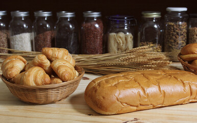 Fresh Baked Bread in Rustic Kitchen on Wooden Table With Jars of Dried Food in Background Shallow DOF