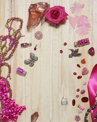 Pink and Magenta Jewelry With Flower on Wooden Table. Top View