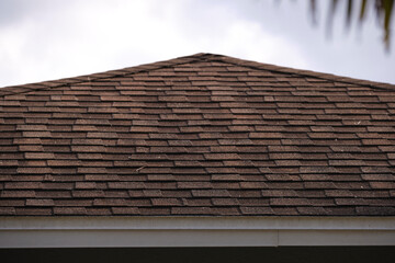 Closeup of house roof top covered with asphalt or bitumen shingles. Waterproofing of new building