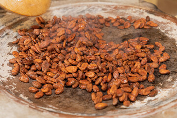 Closeup of the texture of cacao beans roasting on a hot comal 