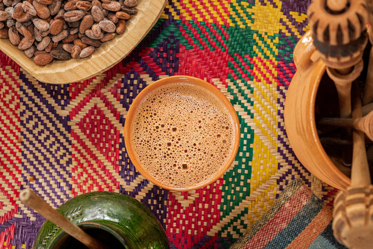 A cup of a traditional Oaxacan chocolate next to molinillos